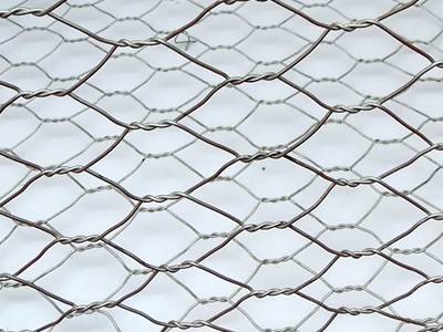 Two pieces of galvanised chicken wire mesh on the white background.