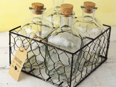 Four bottles are paced inside a chicken wire mesh made basket.